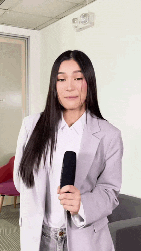 a woman in a blazer is holding a microphone