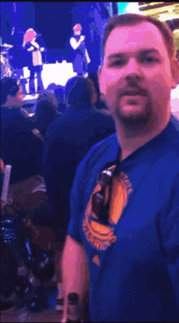 a man wearing a golden state warriors shirt is dancing in a crowd
