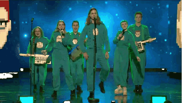 a group of people in green jumpsuits are singing and playing instruments