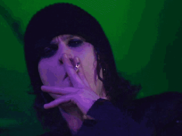 a person smoking a cigarette with a purple background
