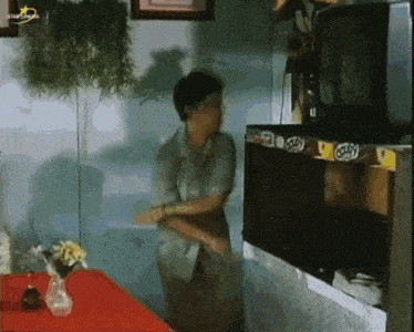 a woman is standing in front of a television in a room that says star channel on the bottom