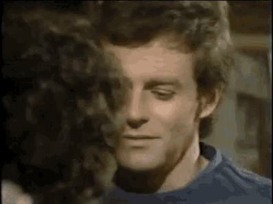 a close up of a man 's face in a blue shirt .