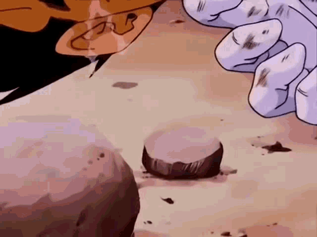 a close up of a cartoon character 's hands holding a rock .