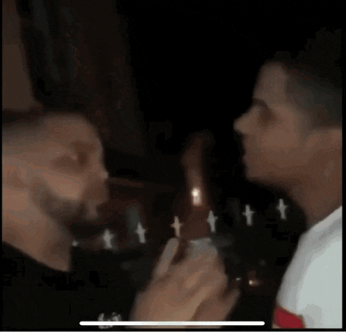 two people are kissing in a dark room .