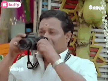 a man is taking a picture with a camera while wearing a white shirt .