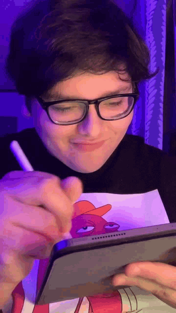 a man wearing glasses is writing on a tablet with a pen