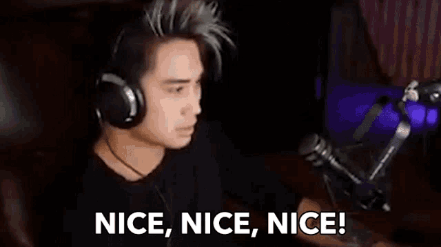 a man wearing headphones is sitting in front of a microphone and saying `` nice , nice , nice ! ``