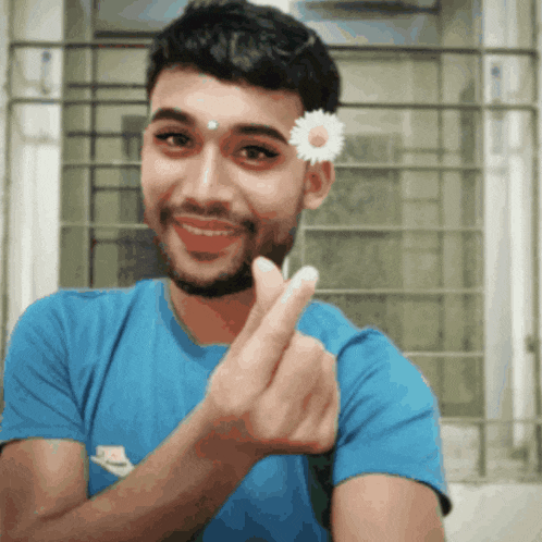 a man wearing a blue nike shirt is holding a small flower in his hand