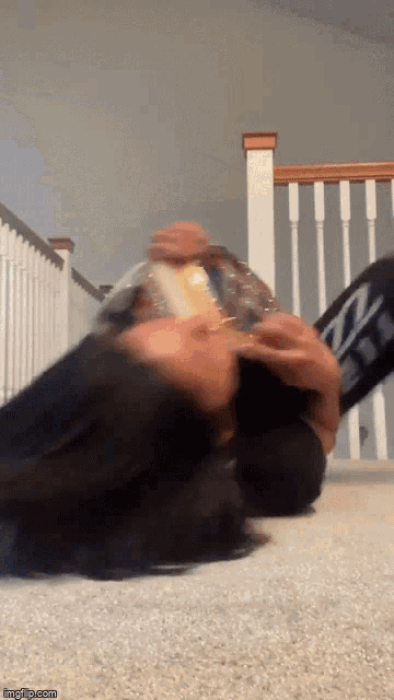 a person laying on the floor with a bag of chips in their hand and a sign that says imgflip.com
