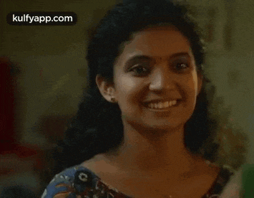 a woman is smiling and looking at the camera in a blurry photo .