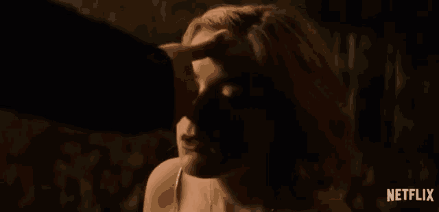 a close up of a person touching a woman 's forehead with the netflix logo in the corner