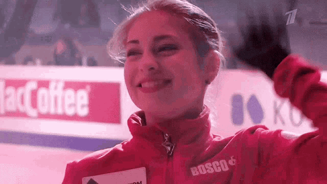 a woman wearing a red jacket with bosco on the front