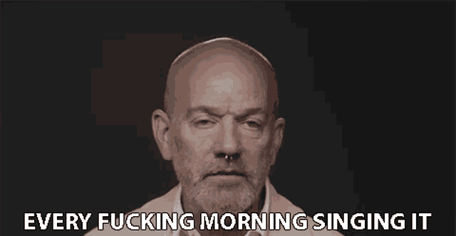 a bald man with a beard and nose ring is singing every fucking morning singing it .