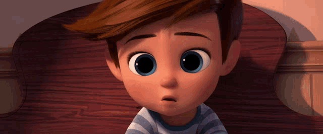 a little boy with big blue eyes is sitting on a chair