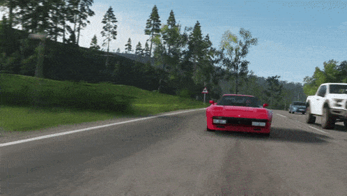 a red sports car is driving down a road