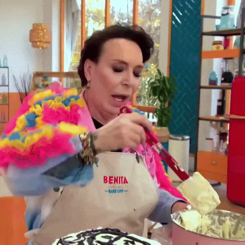 a woman wearing an apron that says benita on it is making a cake .