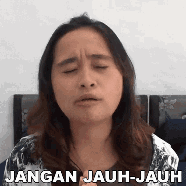 a woman making a funny face with the words jangan jauh-jauh written below her