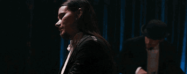 a man in a suit and tie is playing the piano