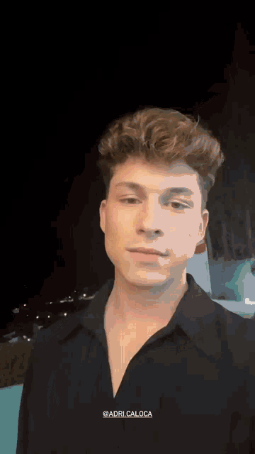 a young man is wearing a black shirt with the name adri caloca on the bottom