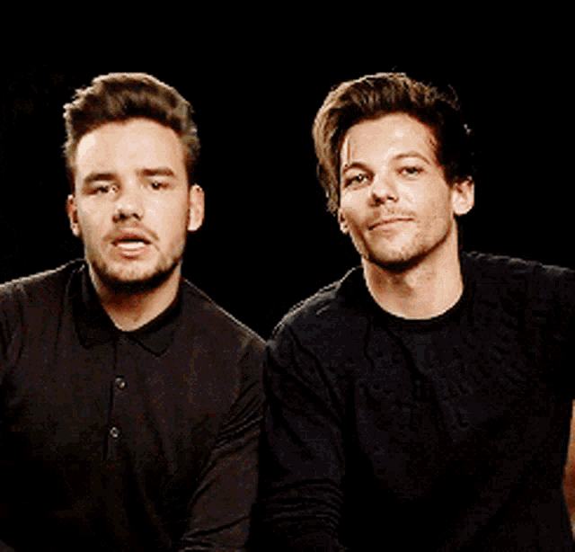 two men sitting next to each other with one making a surprised face