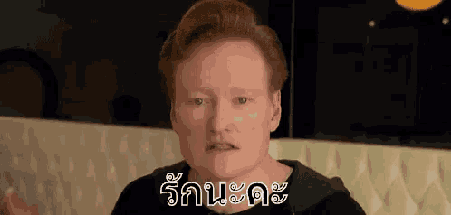 a man with red hair is making a funny face while sitting on a white couch .
