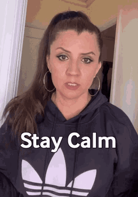 a woman wearing a black adidas sweatshirt says stay calm