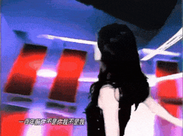 a woman with long black hair stands in a room with chinese writing