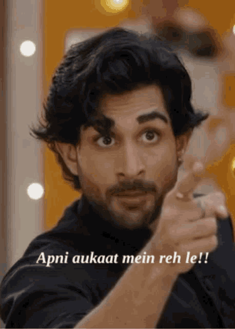 a man with a beard is pointing at the camera with the words apni aukaat mein reh le written below him