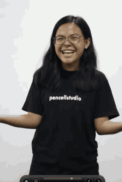 a woman wearing a black shirt that says pencellstudio is smiling