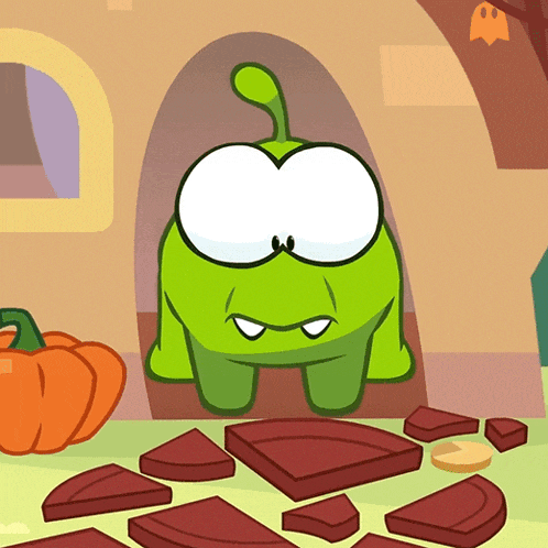 a green cartoon character is standing next to a pumpkin and chocolate pieces