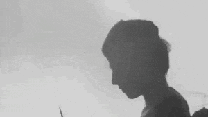 a black and white silhouette of a person holding a bottle .