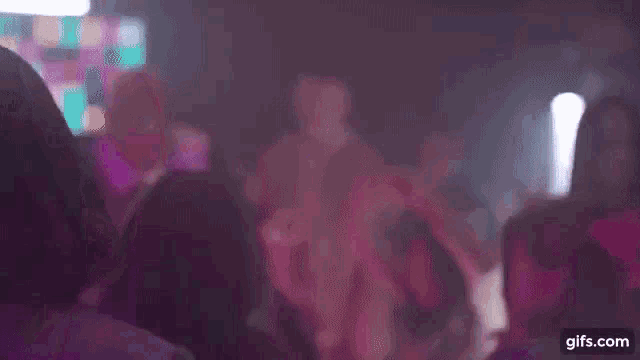 a group of young girls are dancing in front of a red wall .