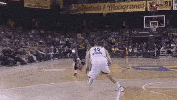 a basketball player wearing a number 13 jersey dribbles the ball