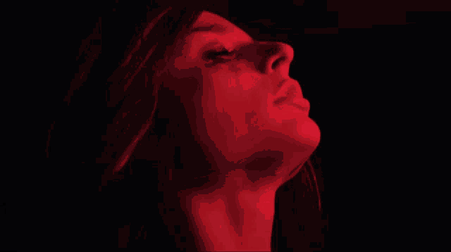 a close up of a woman 's face with red lights