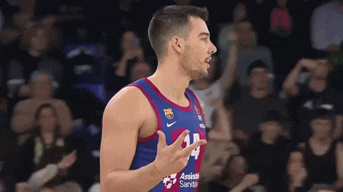 a basketball player wearing a number 14 jersey stands in front of a crowd