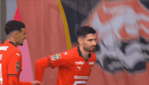 a soccer player wearing a red jersey with the number 5 on the back