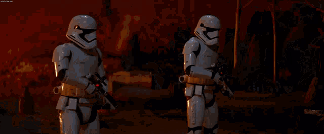 a group of stormtroopers standing in front of a burning building
