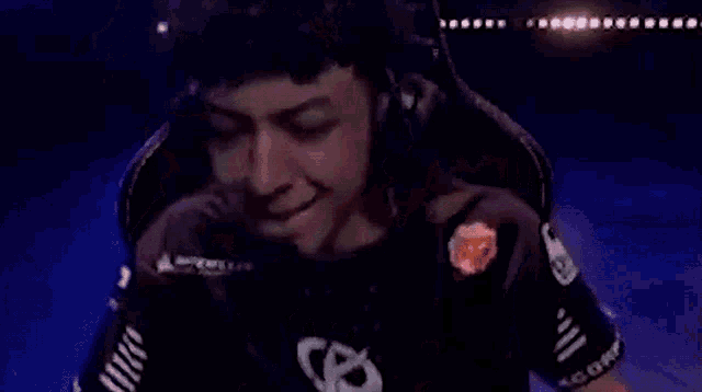 a man wearing headphones and a black shirt with the letter s on it