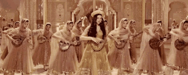 a woman in a yellow dress is dancing with a group of women playing guitars .