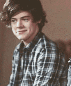 a young man in a plaid shirt is smiling