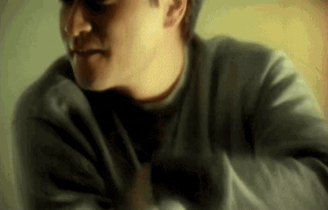 a man in a grey sweater is looking down