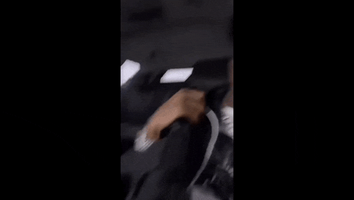 a man is holding a gun in his hand while sitting on a bed .