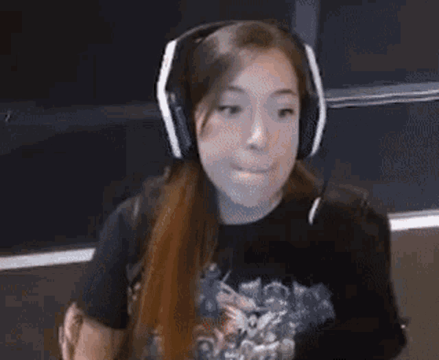 a woman wearing headphones and a microphone is sitting in front of a microphone .