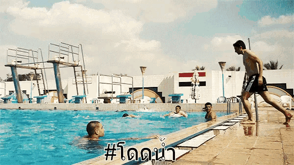 a man is jumping into a swimming pool with #todona written on the bottom