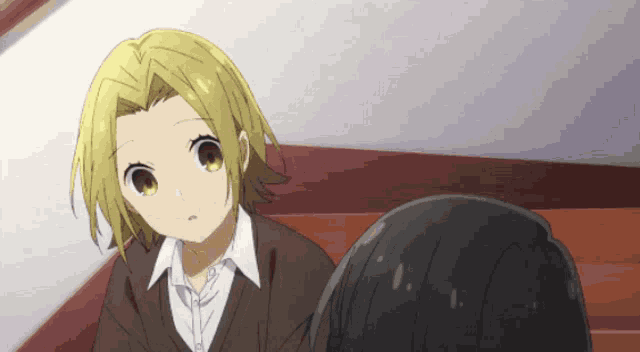 a girl with blonde hair is sitting next to another girl with black hair