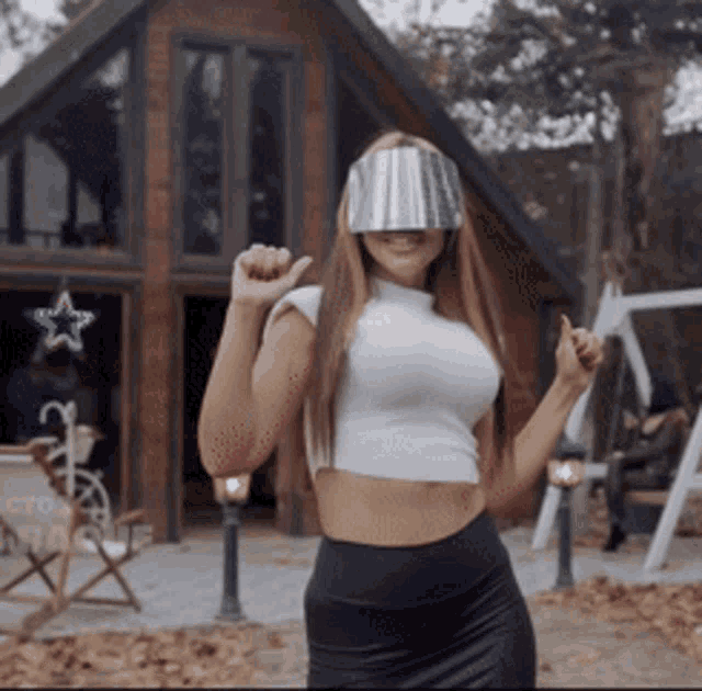 a woman wearing a crop top and a bucket on her face