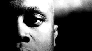 a black and white photo of a man 's face with a shadow on his forehead .