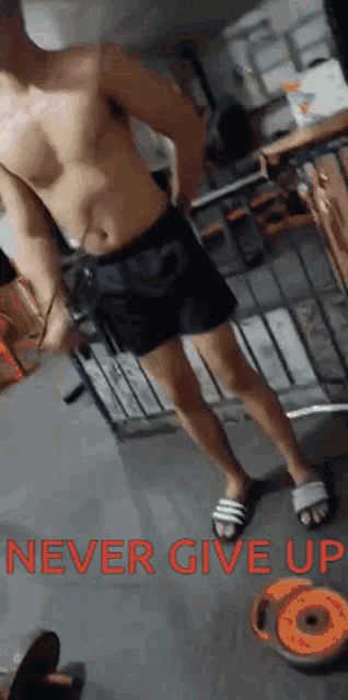 a man without a shirt is standing in a room with the words " never give up " on the floor