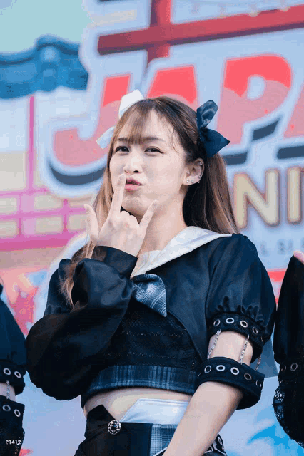 a girl making a funny face in front of a sign that says " n "