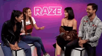 a group of people are sitting on boxes talking to each other .